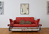 Auf dem Bild ist ein rotes Sofa im Stil eines amerikanischen 50er-Jahre-Autos zu sehen. Auf dem Sofa ist ein Torso als Ausstellungsstück plaziert.