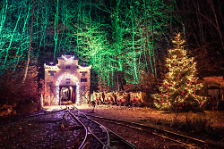 Auf dem Bild ist der weihnachtlich geschmückte Eingang des Besucherbergwerks Tiefer Stollen in der Dunkelheit zu sehen.