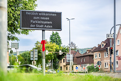 Das Bild zeigt eine digitale Tafel. Auf der Tafel steht: "Herzlich willkommen zum neuen Parkleitsystem der Stadt Aalen".