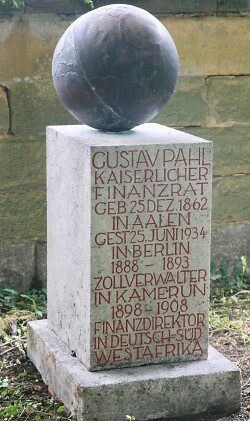 Das Bild zeigt einen Grabstein in Form einer niedrigen Stele, gekrönt von einer Kugel. Eingemeiselt sind die Lebensdaten des Begrabenen, Gustav Pahl