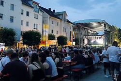 Auf dem Foto sind viele Gäste auf dem Stefansplatz zu sehen. Im Hintergrund erkennt man die große Musikbühne.